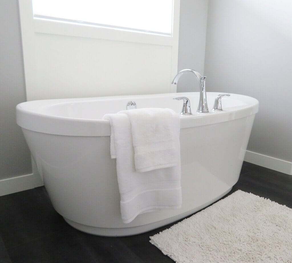 Bathroom with white bath tub by a window