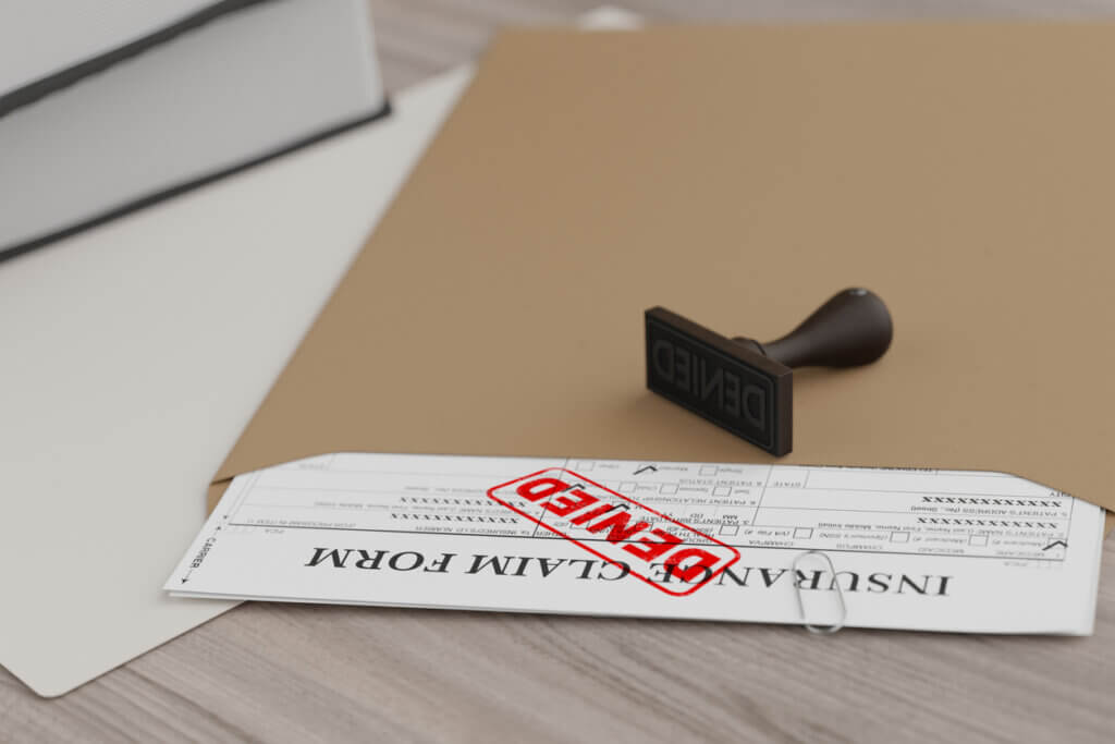 Document with denied stamp and a stamper put on the wooden table